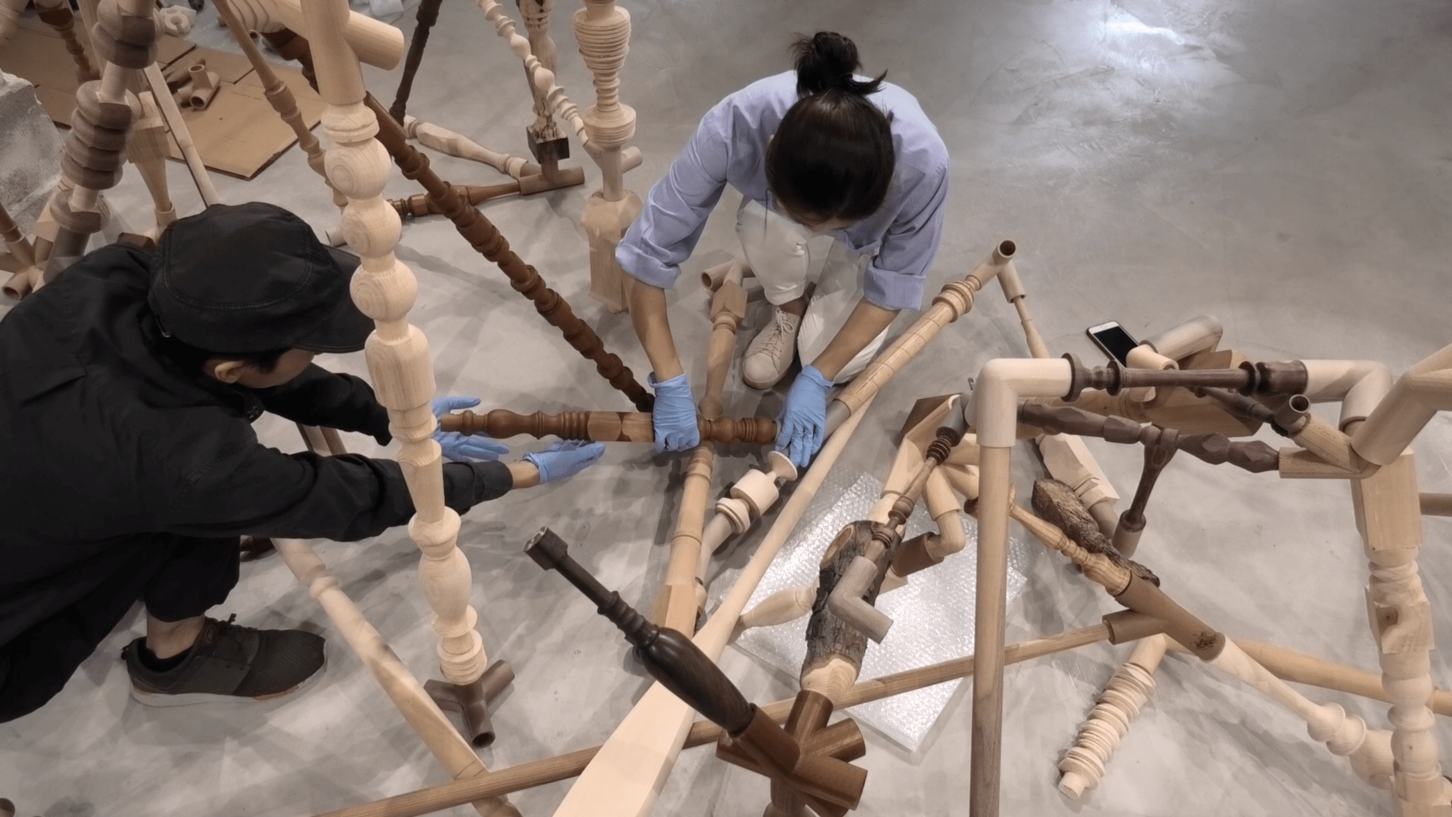 Gallery Interns Sai Wing (left) and Annie Lye (right) amending artwork 'Negotiated Differences' by Shirley Tse, HK Pavilion, Venice Biennale 2019.